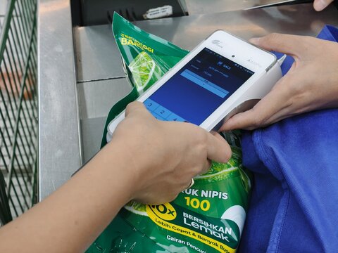 ​Jakarta, Indonesia - 14 December 2025: Customer using a Visa credit card with a modern PAX A920Pro mobile smart Point-of-Sale (POS) terminal for payment at a retail checkout counter