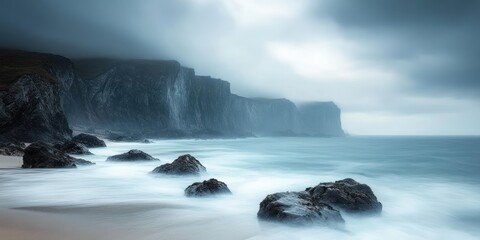 misty coastal cliffs and rocky shoreline with blurred waves under a brooding overcast sky, a tranquil and moody seascape
