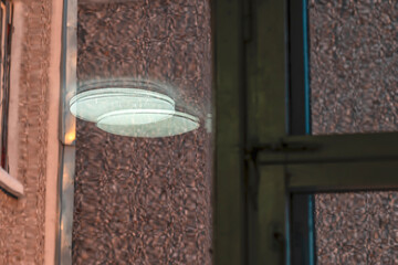 The ceiling lamp is reflected in the window glass on a winter day