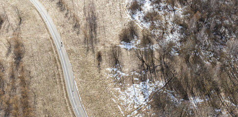 park landscape on sunny cold spring day. empty bike lane pass through park. aerial panoramic view.