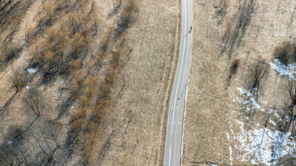 aerial view of park landscape with empty footpath and bike lane at bright sunny day on early spring.