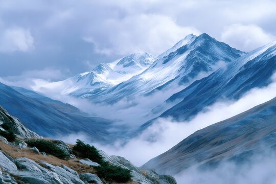 Snowcapped mountains with valley shrouded in mist and clouds