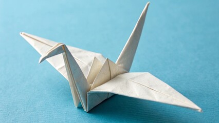 Close Up of Paper Origami Bird Craft on Blue Background for Creative Hobby