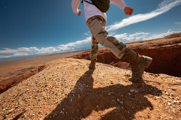 Close up photo of walking in desert hiker legs. Desert vacations travel