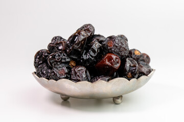 Ajwa Dates in a metal bowl isolated on white background