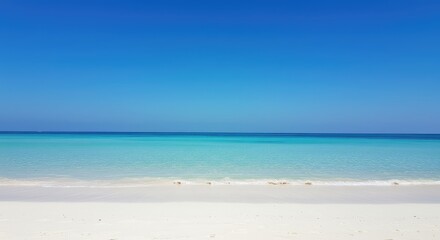 Fototapeta premium A tranquil beach scene under a vast azure sky. Clear, soft-focus ocean meets pristine white sand