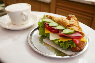 Enjoying a sandwich and coffee at a cafe table