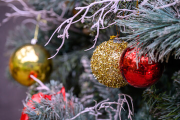 Close-up of a beautifully decorated ornament hanging on a artificial Christmas tree.