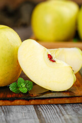 Fresh Yellow Apples Sliced with Mint on Wooden Board