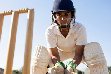 Focused Female Cricket Wicket-keeper Ready for Action on Field