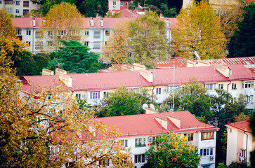 An aerial view of a residential area of the city. Multi-story apartment buildings with red roofs are visible.