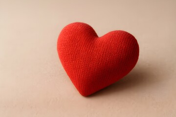 Fototapeta premium A red heart centered on a beige background, symbolizing love and affection.