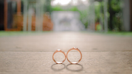 wedding rings on a wooden base with a wedding altar background