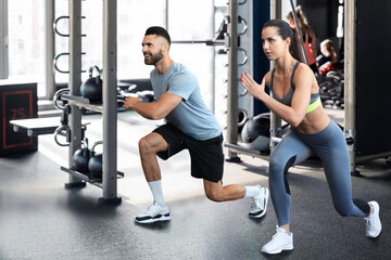 Attractive sport couple doing fitness at gym.