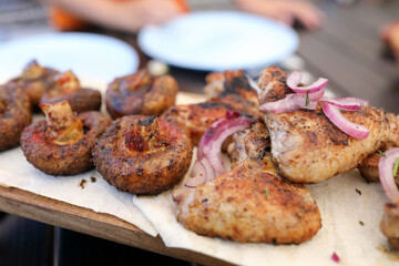 Grilled chicken drumsticks and mushrooms with red onion
