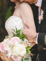 the groom kisses the brides shoulder