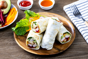 Chicken breast with caesar dressing and lettuce in a gluten-free tortilla wrap, tasty food