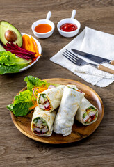 Chicken breast with caesar dressing and lettuce in a gluten-free tortilla wrap, tasty food