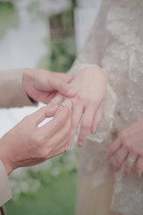 the groom puts the ring on the bride
