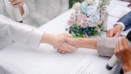 the groom and the marriage guardian are performing the marriage contract