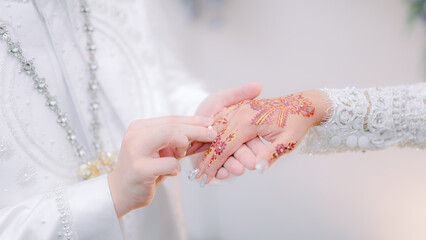 the groom puts the ring on the bride