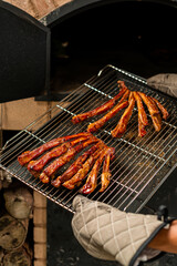 The chef was holding an iron baking tray in his hands, on which were roasted lamb chops and various seasonings.