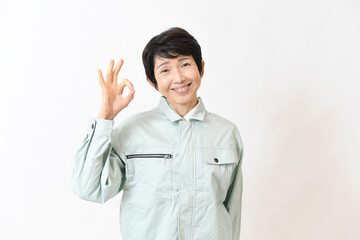 OKサインをする作業服姿のアジア人女性