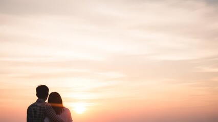 Romantic couple embracing and watching the beautiful sunset together, enjoying a peaceful evening outdoors.