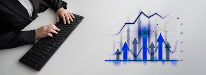 A business professional uses a keyboard while analyzing financial data represented through dynamic graphs and charts in a modern office setting. Scalp