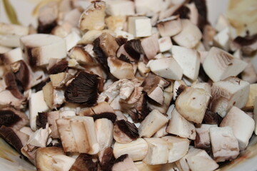 Chopped mushrooms and tofu mixed together on a cutting board ready for cooking in a kitchen