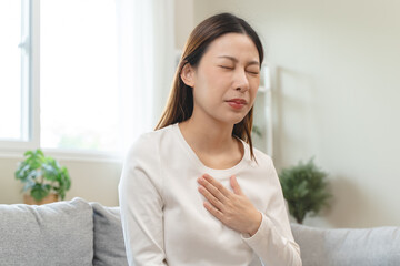 Acid reflux disease, suffer asian young woman have symptom gastroesophageal, esophageal, stomach ache and heartburn pain hand on chest from digestion problem after eat food, Healthcare medical concept