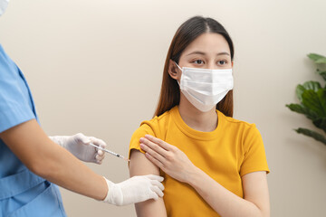 People getting a vaccination to prevent pandemic concept. Woman in medical face mask receiving a dose of immunization coronavirus vaccine from a nurse at the medical center hospital