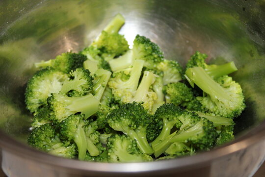 Fresh broccoli pieces placed in a metal bowl ready for cooking or salad preparation in a kitchen