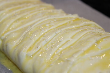 Freshly baked pastry with glaze resting on parchment paper after oven