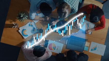 A diverse group of professionals engaged in a business meeting, analyzing financial data and charts on a modern table, showcasing collaboration and growth strategy. Axiom