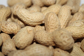Peanuts in their shells displayed on a flat surface in a close view during daylight hours
