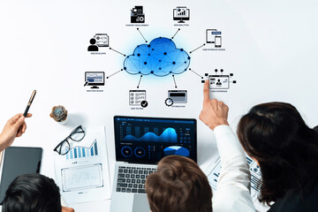 A collaborative business team engages in cloud computing solutions with digital analytics, showcasing data visualization tools in a professional workspace setting. Trope