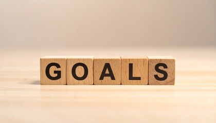 Wooden blocks spelling &ldquo;GOALS&rdquo; on light wood surface with soft blurred background.