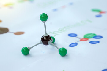 A colorful ball-and-stick model representing a covalent molecule (e.g., Tetrahedral or Carbon compound) displayed in a chemistry lab or classroom setting. Focuses on science education.