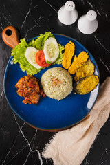 Delicious Fried Chicken Rice Plate with Salad and Plantains.