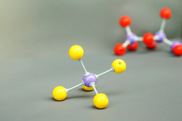 A colorful ball-and-stick model representing a covalent molecule (e.g., Tetrahedral or Carbon compound) displayed in a chemistry lab or classroom setting. Focuses on science education.