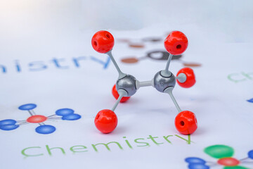 A colorful ball-and-stick model representing a covalent molecule (e.g., Tetrahedral or Carbon compound) displayed in a chemistry lab or classroom setting. Focuses on science education.