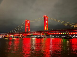 Fototapeta premium The view at night on the Ampera Bridge in Palembang, South Sumatra, Indonesia