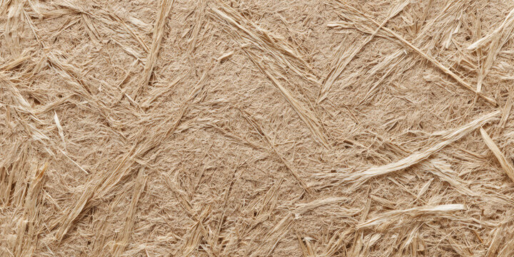 Macro close-up of wheat straw fiberboard featuring compressed plant fibers, earthy beige tones and a sustainable eco-friendly building material texture