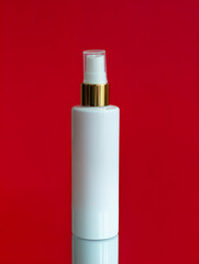 White cosmetic bottle mockup on red background