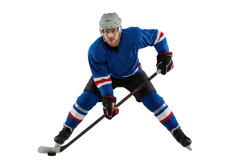 Hockey player in blue uniform skating with puck isolated on white background