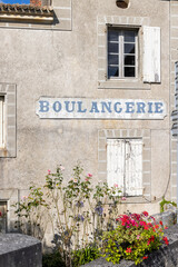 Traditional boulangerie shopfront with blooming flowers in Combiers France