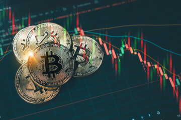 A shiny gold Bitcoin coin stacked on other coins, set against a dark background with red and green candlestick charts illustrating a volatile cryptocurrency market downtrend.