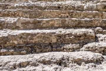 Cadiz, Spain - April 16, 2025: Ruins of Roman theater of Cadiz, with tourists swimming in the sea during the Easter holidays in Cadiz, Spain.