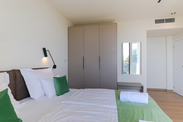  Modern open-plan living and dining room in a luxury villa with large glass doors opening to a private swimming pool, offering a spacious and elegant indoor-outdoor living experience